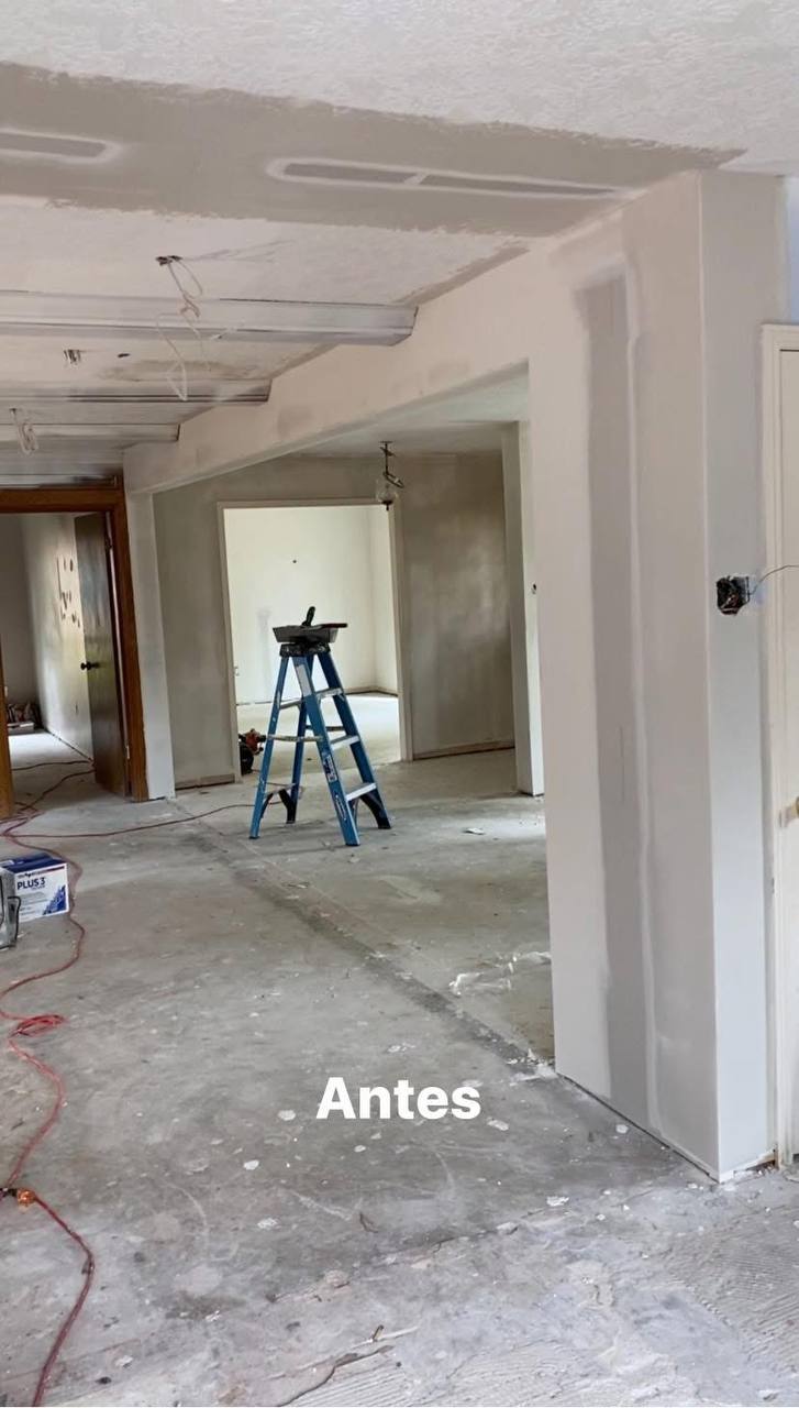 Living area gut — bare concrete, open ceilings, rough drywall